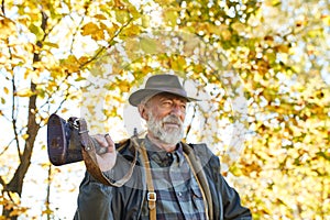 Senior hunter carrying rifle gun on shoulder