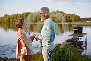 Senior husband confessing his love to wife during walk near river