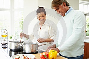 Senior Indian Couple Cooking Meal At Home