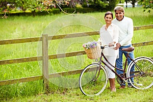 Senior Indian Couple On Cycle Ride In Countryside