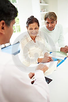 Senior Indian Couple Meeting With Financial Advisor At Home