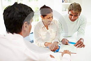 Senior Indian Couple Meeting With Financial Advisor At Home