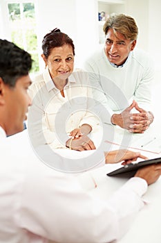 Senior Indian Couple Meeting With Financial Advisor At Home