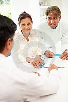 Senior Indian Couple Meeting With Financial Advisor At Home