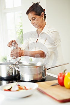 Senior Indian Woman Cooking Meal At Home