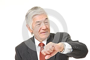 Senior Japanese businessman checking time on his watch