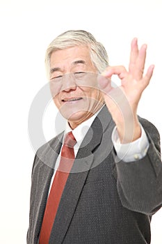 Senior Japanese businessman showing perfect sign