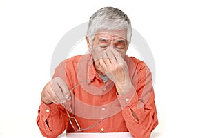 Senior Japanese man suffers from Asthenopia headache, man, tired, sick, isolated, stress, stressed, sad, portrait, head, problem, photo