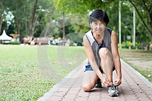 Senior jogger tighten her running shoe laces