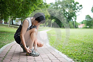 Senior jogger tighten her running shoe laces photo