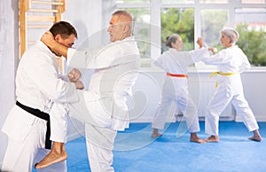 Senior judo practitioner engage in fierce fight