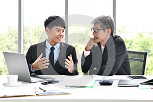 Senior and junior businessman discuss something during their meeting, Asian businessman, business concept