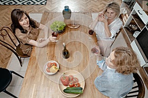 Senior Ladies Drinking Wine And Talking About News In Their Lives. Top View. Active Lifestyle At Middle Age. Living Full Life.