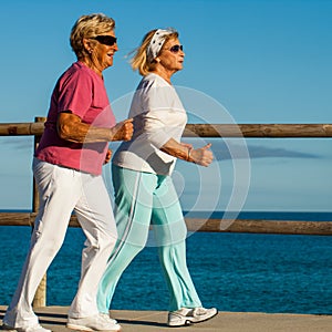 Senior ladies jogging at seaside.