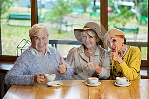 Senior ladies showing thumbs up.