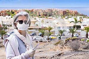 Senior lady with face mask and protective gloves going to the pharmacy - permission to go out of necessity at the time of