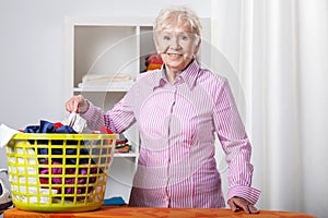 Senior lady during folding laundry