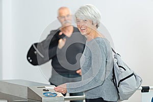 Senior lady going through ticket machine turnstile