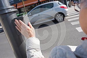 Senior lady hand pressing crossroads button