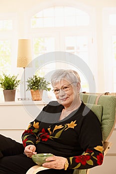 Senior lady having tea at home