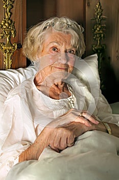 Senior lady in her nightgown in bed