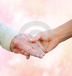 Senior Lady Holding Hands with Young Woman