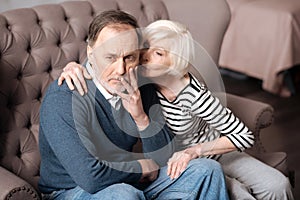 Senior lady kissing her sick husband