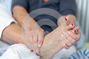 Senior lady massaging her foot