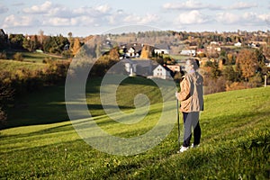 Senior lady nordic walking in the countryside landscape