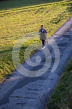 Senior lady nordic walking on the countryside road