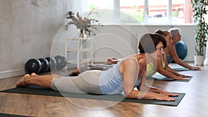 Senior lady performs cobra pose, Bhujangasana