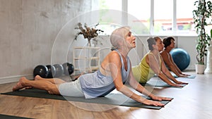 Senior lady performs cobra pose, Bhujangasana