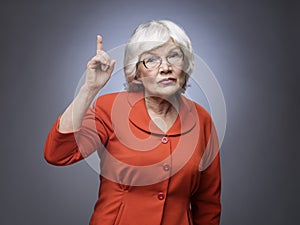 Senior lady points finger up