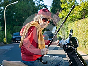 Senior lady on a scooter waving her cane