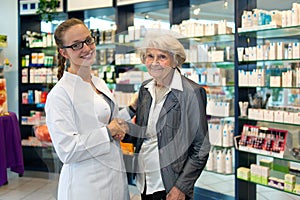 Senior lady shaking hands with a pharmacist