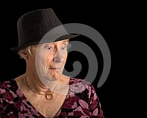 Senior lady with a shocked look on her face wearing a fedora