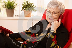 Senior lady using landline phone photo