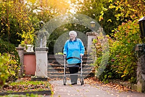 Senior lady with a walker in autumn park