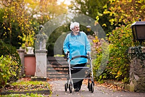 Senior lady with a walker in autumn park