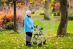 Senior lady with a walker in autumn park