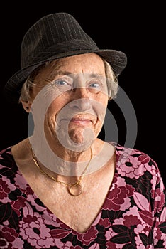 Senior lady wearin a fedora with an amused look on her face