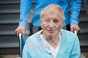 Senior lady in wheelchair with caretaker photo