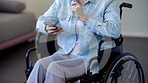 Senior lady in wheelchair chatting on smartphone, modern technologies, gadget