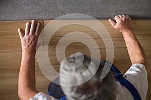 Senior landlord lying parquet floor board/laminate flooring in a rental appartement