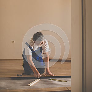 Senior landlord lying parquet floor board/laminate flooring in a rental appartement