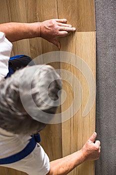 Senior landlord lying parquet floor board/laminate flooring in a rental appartement