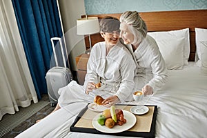 Senior lesbian couple sitting lovingly on