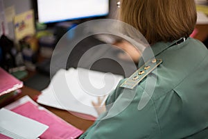 Senior lieutenant in uniform working in office in