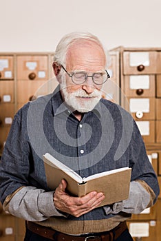 senior male archivist reading photo
