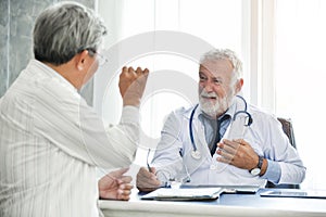 Senior male Doctor and Asian male patient are talking.